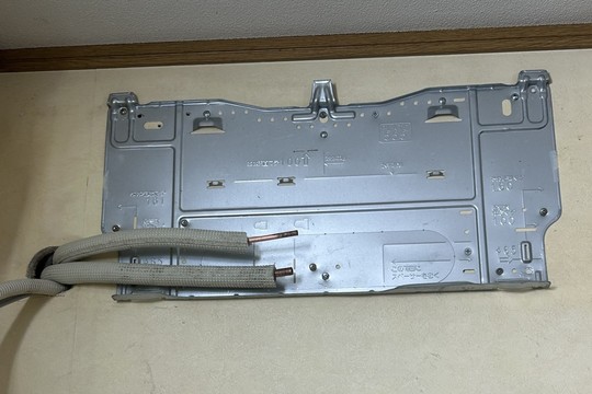 室内の背板をつけて冷媒管を延ばす作業中