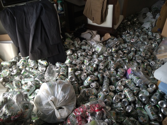 部屋中空き缶が山積みされた汚部屋